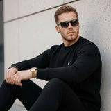 Black crewneck sweatshirt with small chest logo, ribbed cuffs and hem
