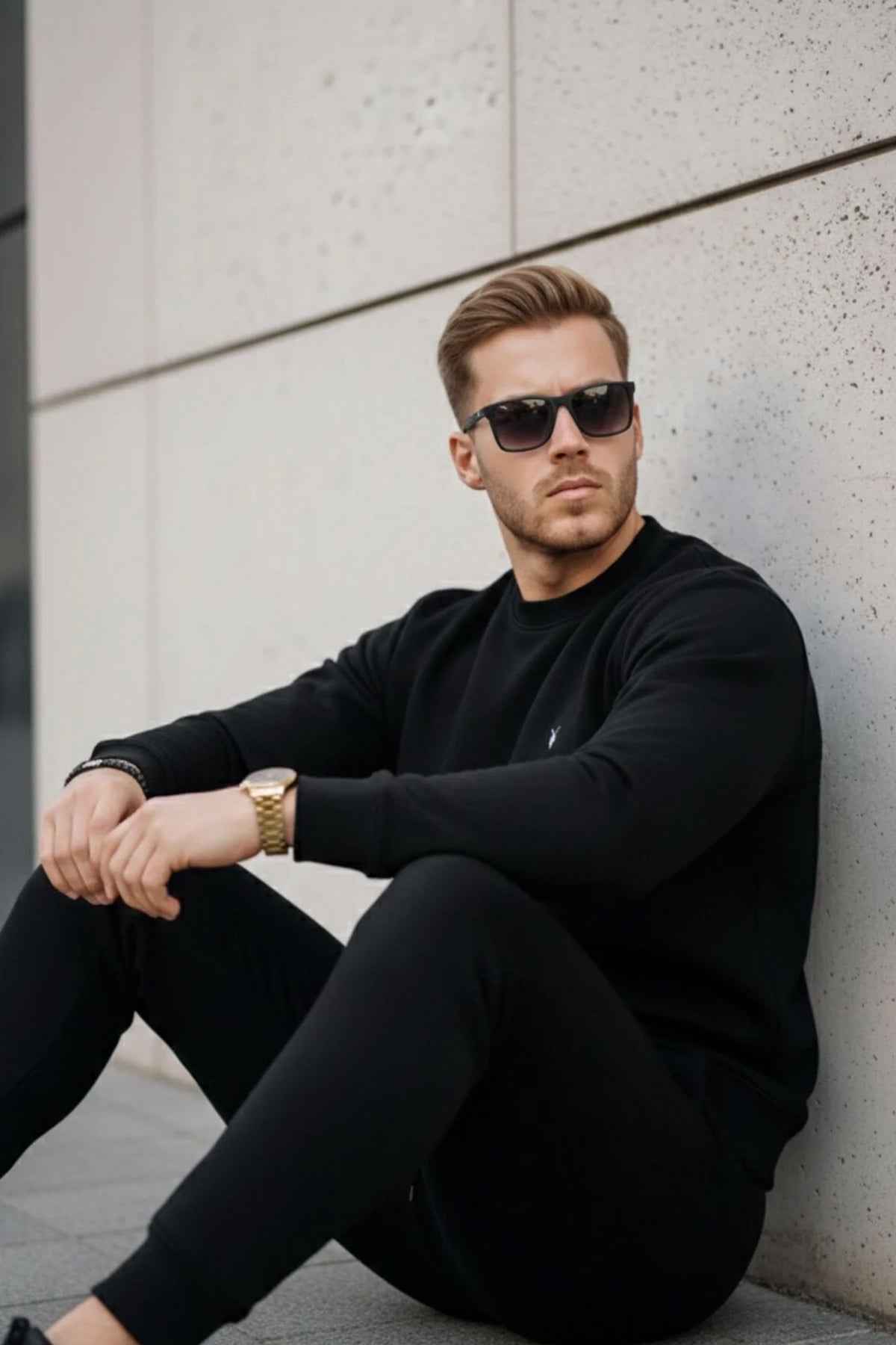 Black crewneck sweatshirt with small chest logo, ribbed cuffs and hem