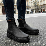 Men's black Chelsea boots with rounded toe and treaded sole