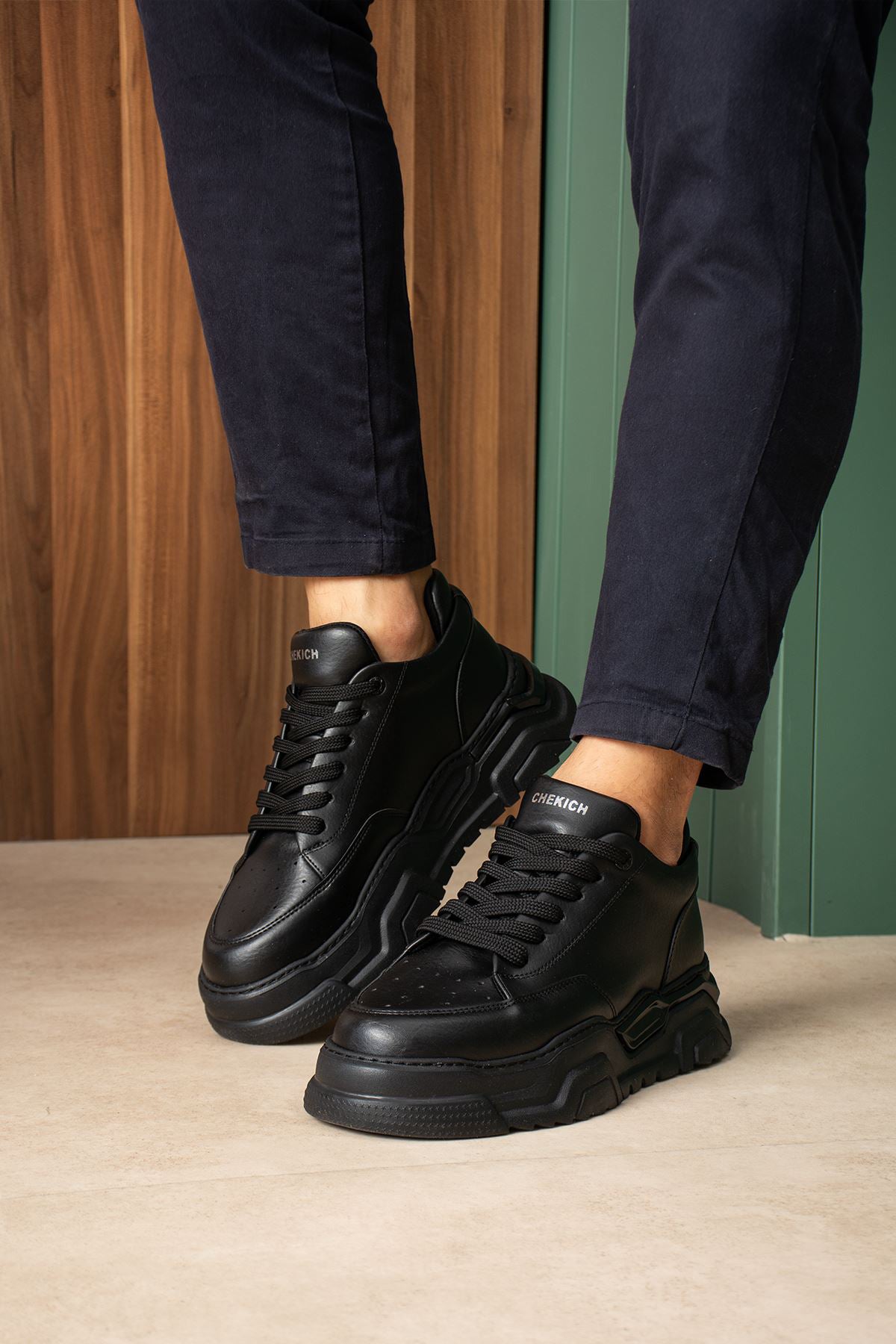 Black lace-up sneakers with side detailing and chunky tread sole