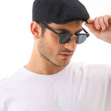 Men's black flat cap being adjusted, curved brim and stitched crown
