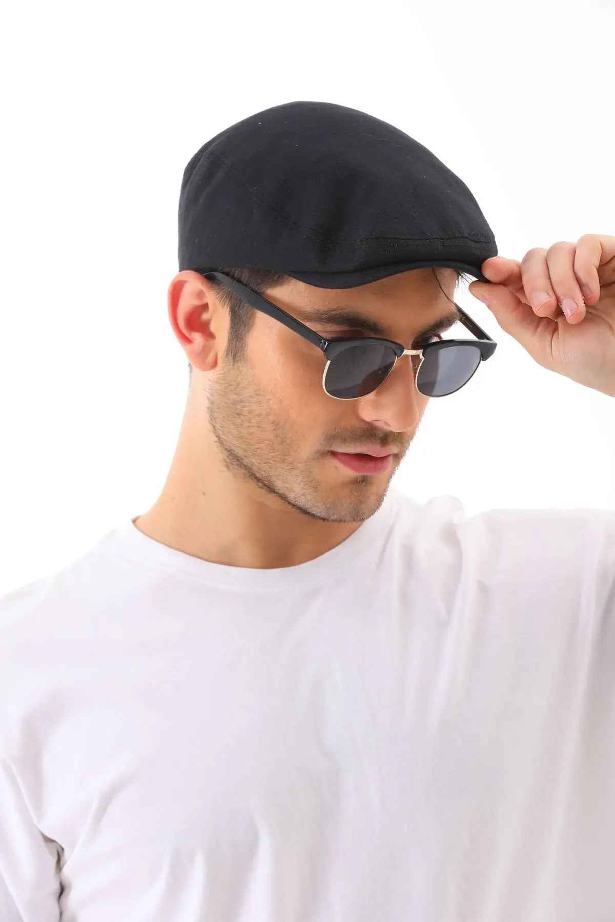 Men's black flat cap being adjusted, curved brim and stitched crown