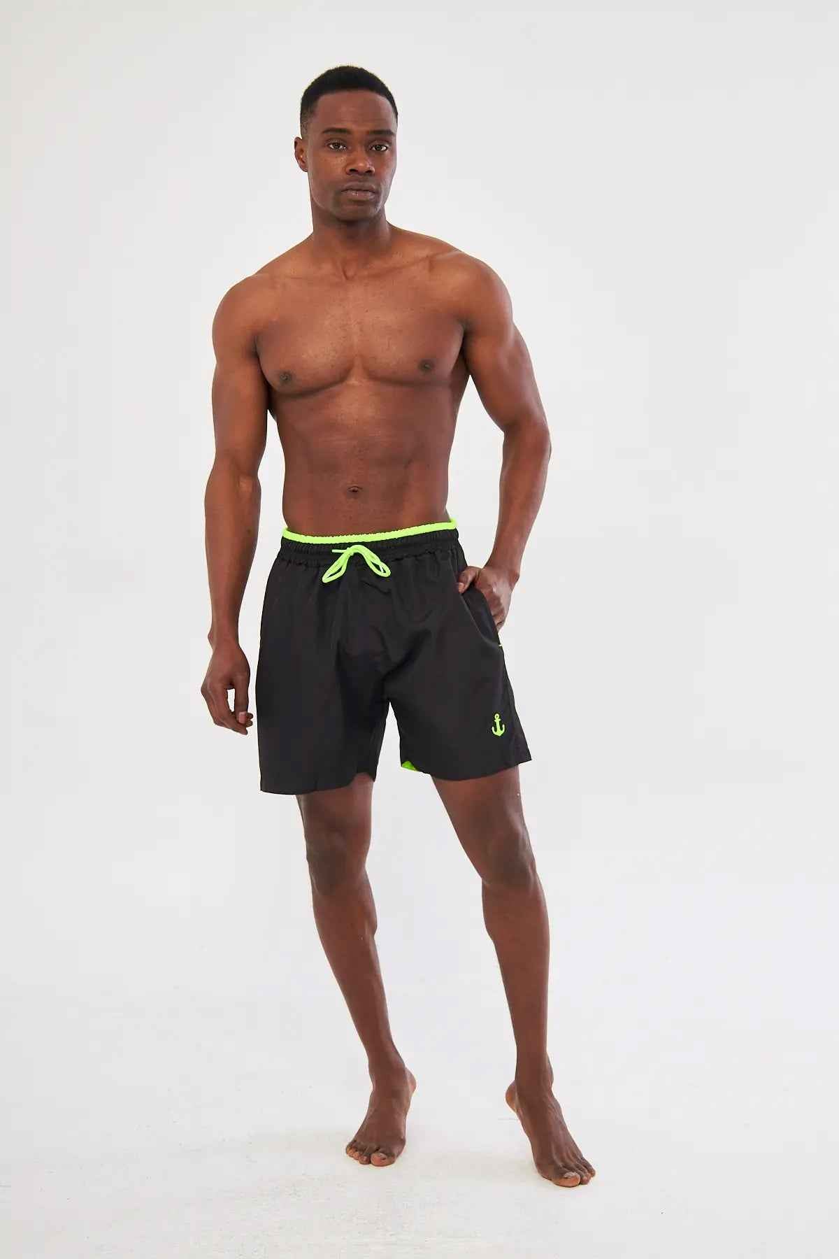 Men's black swimming shorts with neon green drawstring waistband and small side logo
