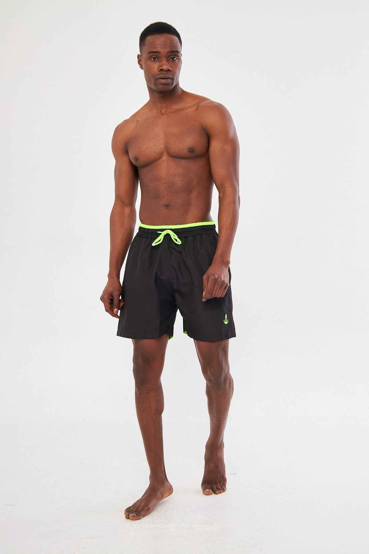 Men's black swimming shorts with neon green drawstring waistband and small side logo