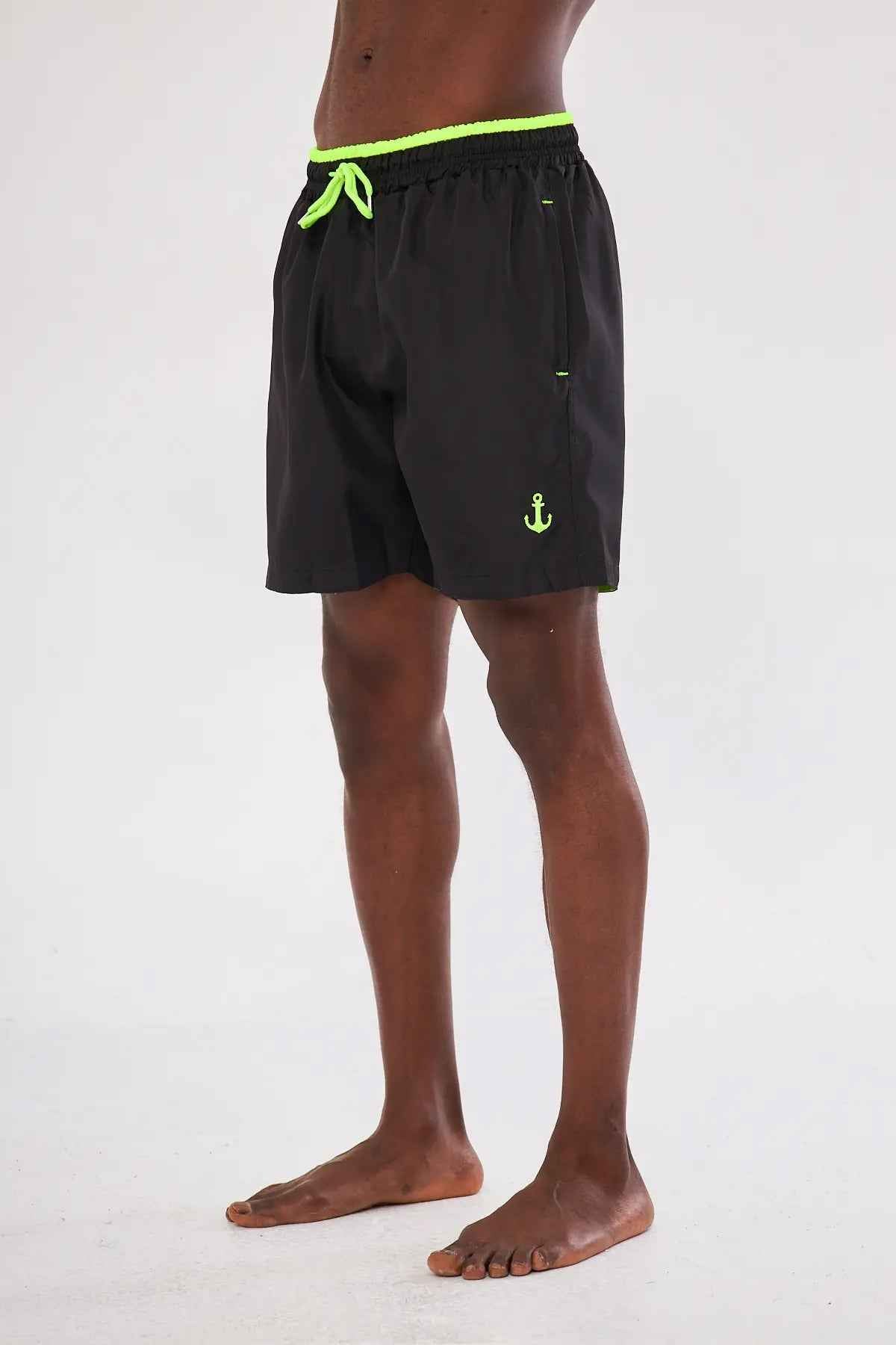 Men's black swim shorts with neon green trim and anchor logo on leg