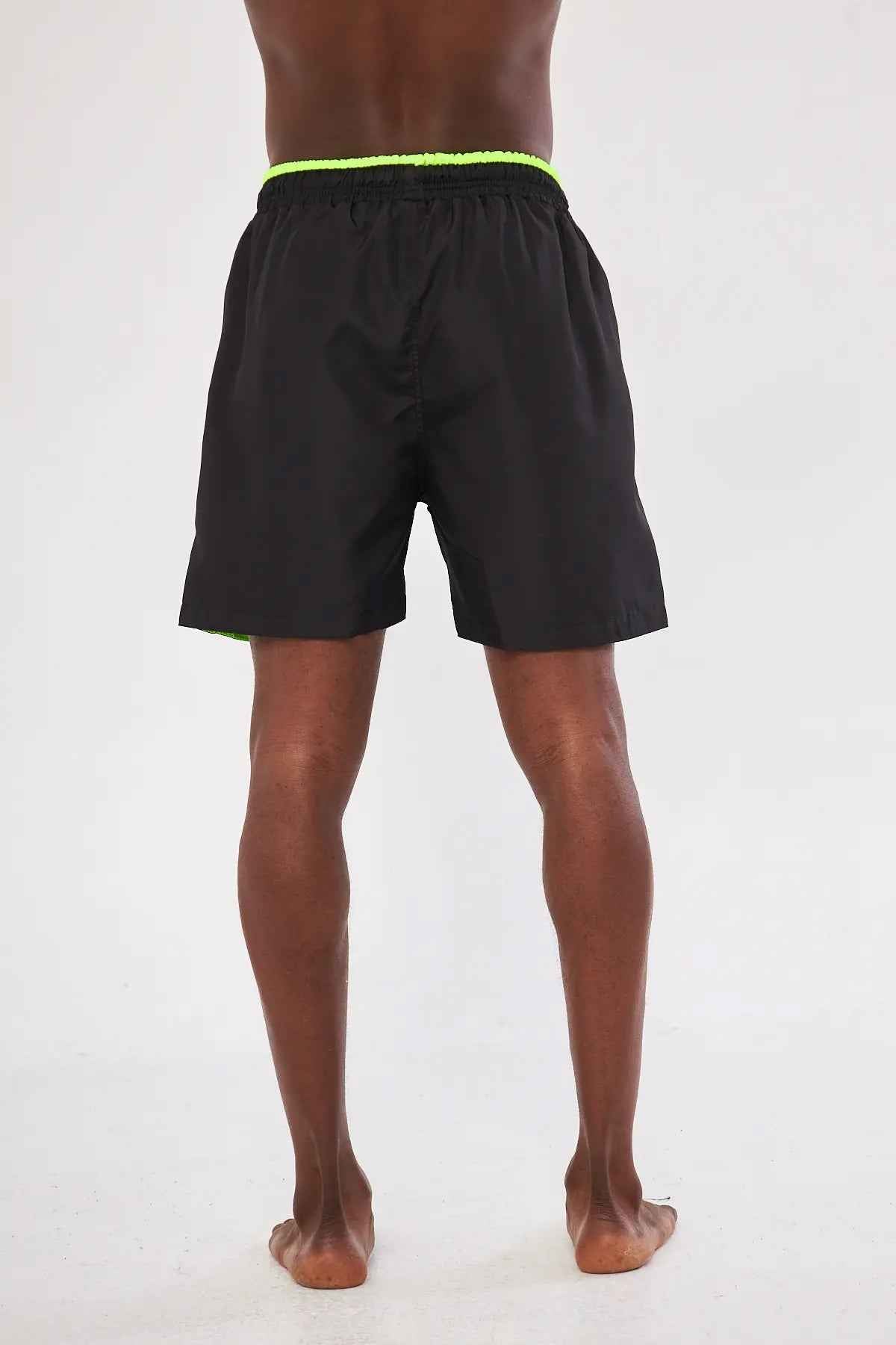 Men's black swim shorts with neon green waistband and back view