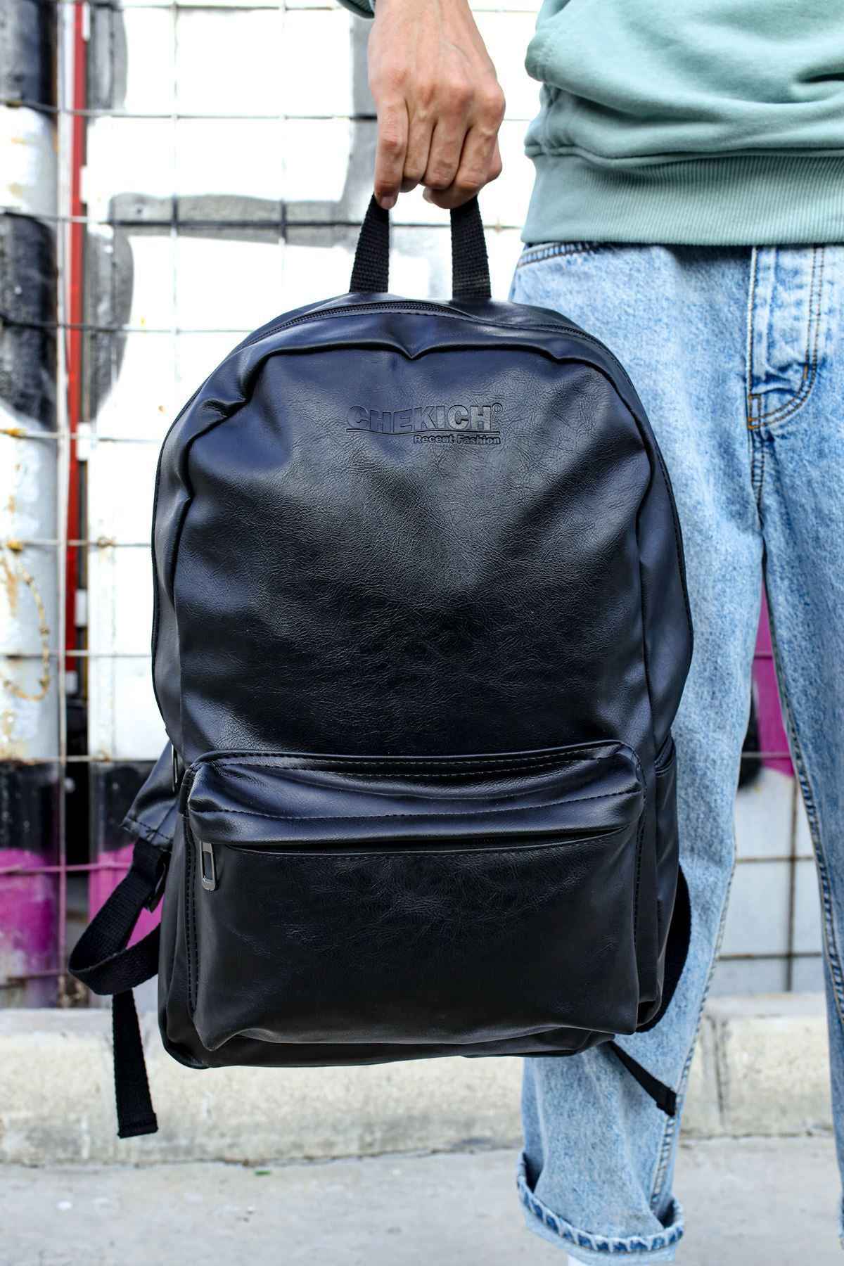 Black leather backpack held by top handle, front zip pocket