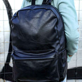 Black leather backpack with two front compartments and adjustable straps