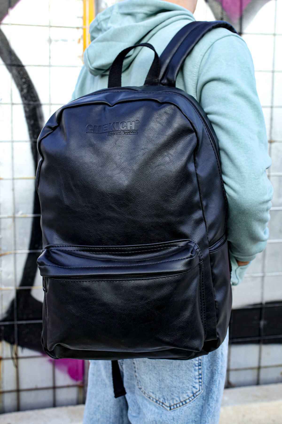Black leather backpack with two front compartments and adjustable straps