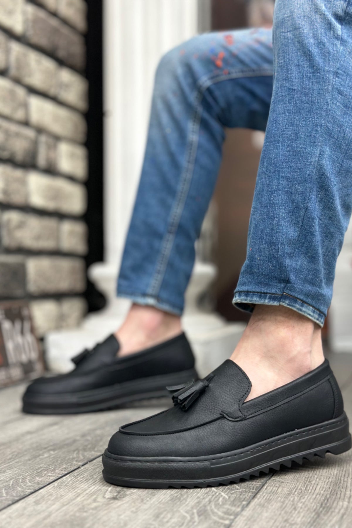 Men's black leather-look loafers with strap across vamp, slip-on design