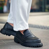 Black chunky loafers with slip-on strap and treaded sole