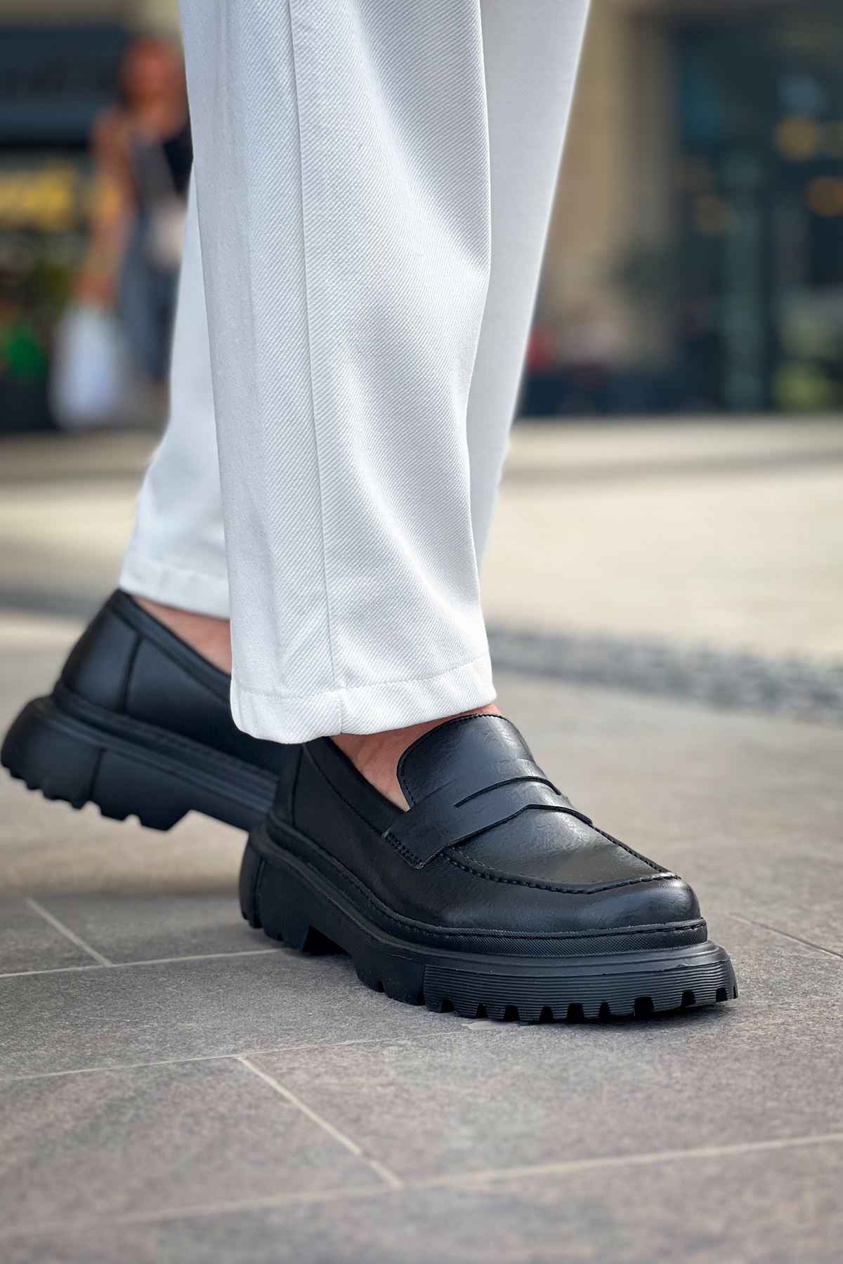 Black chunky loafers with slip-on strap and treaded sole
