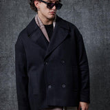 Men's oversized black double-breasted coat with long sleeves and double-row buttons.