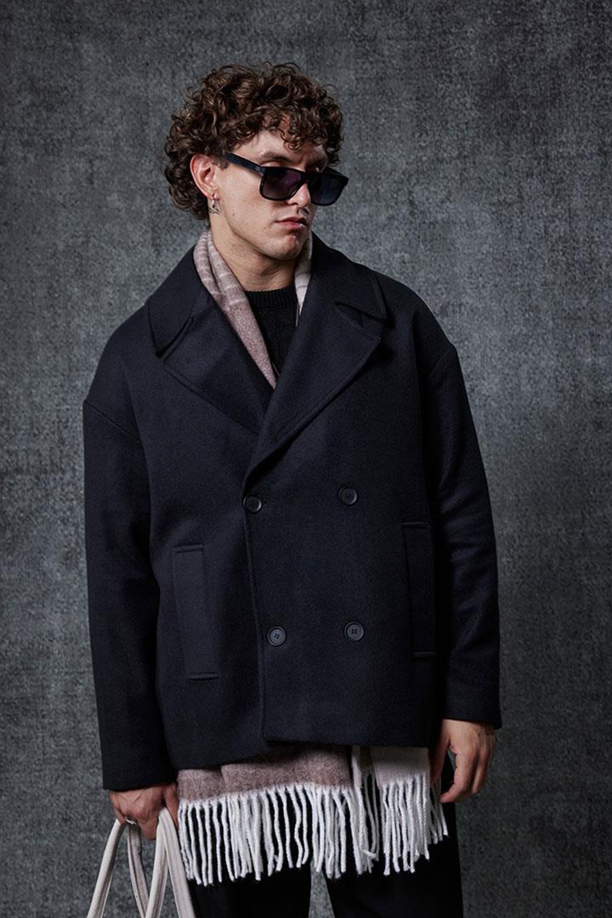 Men's oversized black double-breasted coat with long sleeves and double-row buttons.