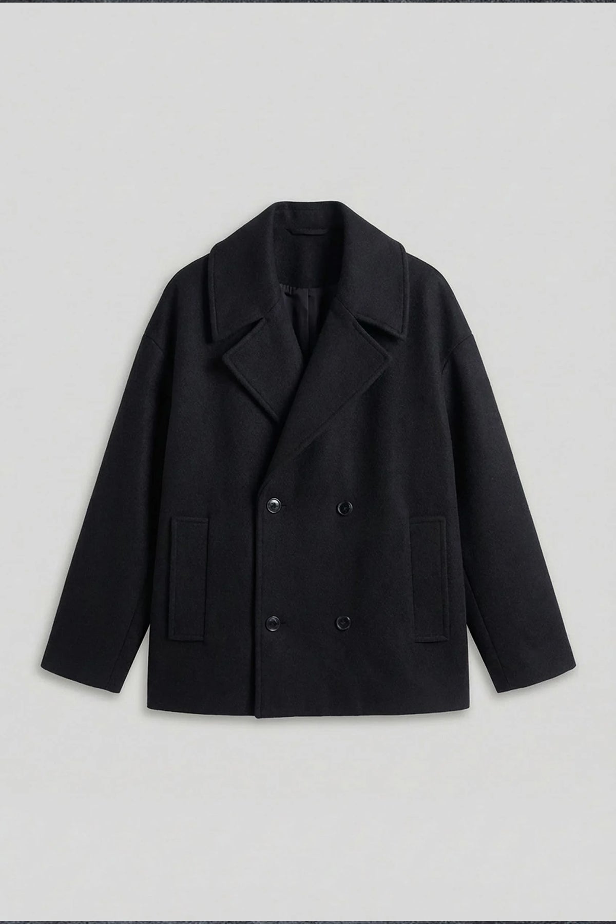 Black oversized double-breasted coat on white background, front view with button closure.