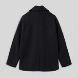 Black oversized double-breasted coat, back view with clean shoulder and center seam.