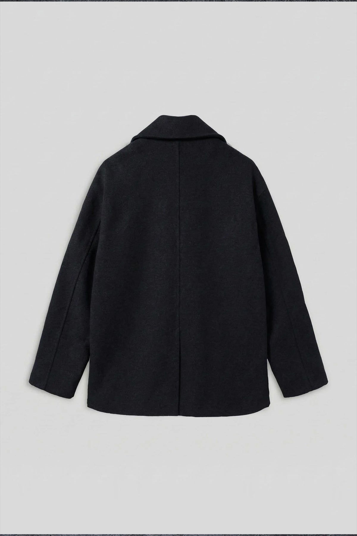 Black oversized double-breasted coat, back view with clean shoulder and center seam.