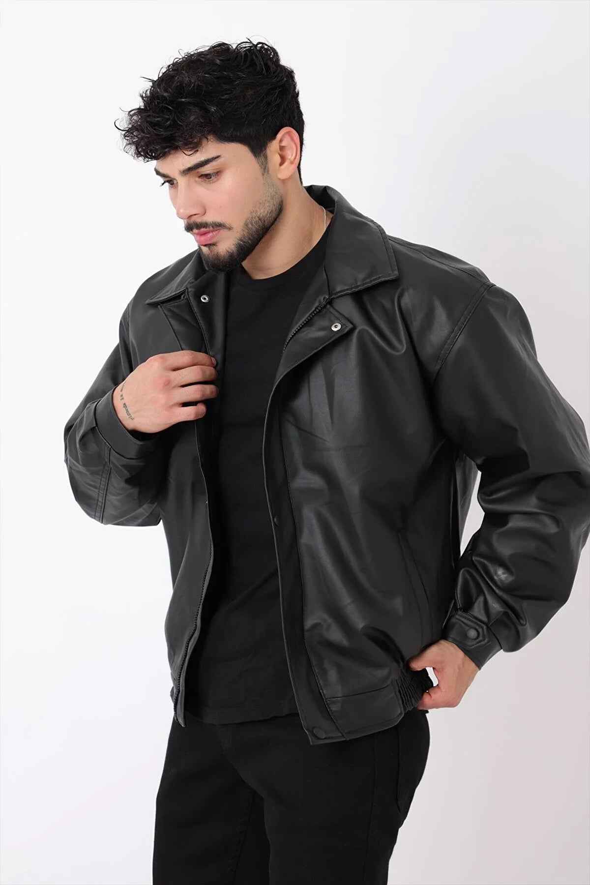 Oversized black leather jacket with snap front and stand collar