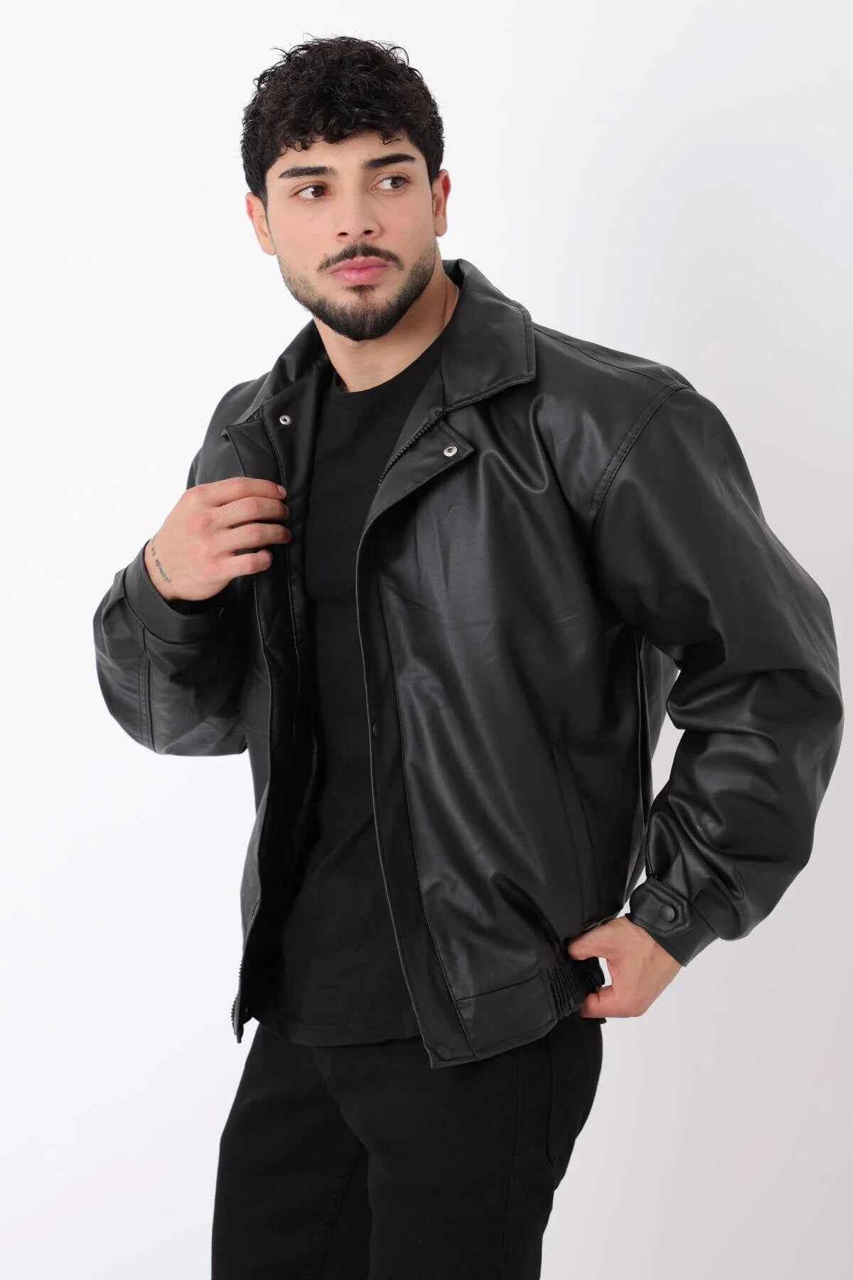 Oversized black leather jacket with snap buttons and front flap pockets
