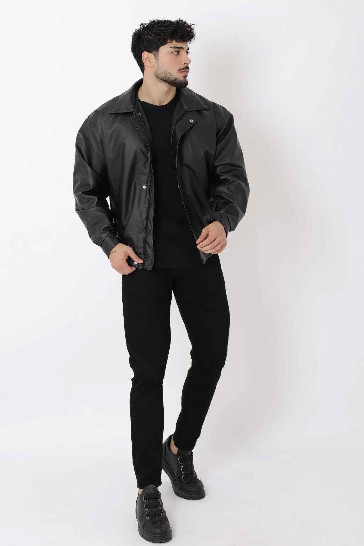 Oversized black leather jacket with stand collar and snap placket, full-body
