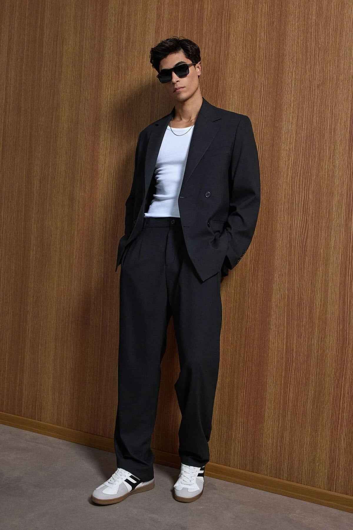 Black oversized suit with jacket and trousers, front view on male model