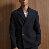 Black double-breasted style suit blazer and matching trousers, front close-up