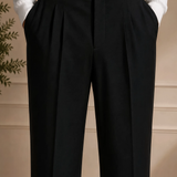Men's black dress pants close-up of waistband with belt and pleats