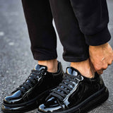 Men's black patent leather sneakers, front-side view with glossy laces and toe