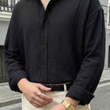 Black button-up shirt close-up with button placket and long sleeves