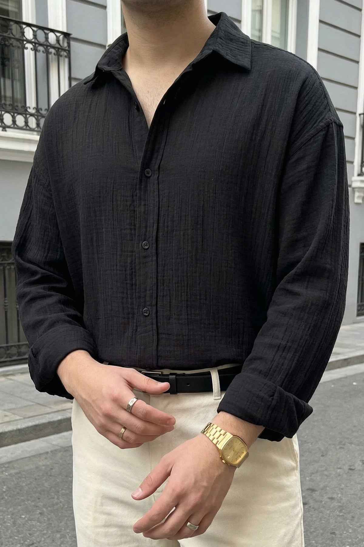 Black button-up shirt close-up with button placket and long sleeves