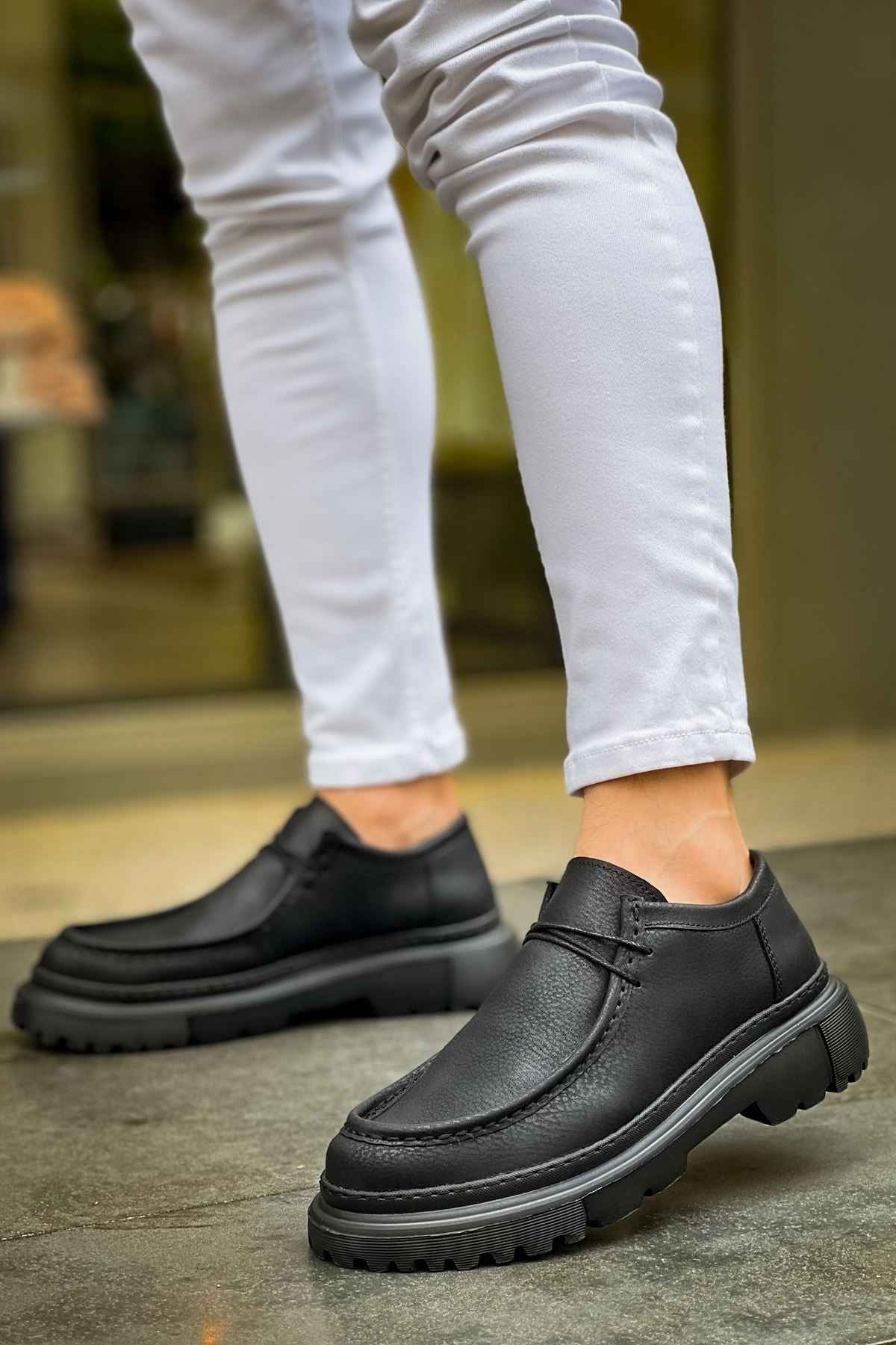 Men's black lace-up shoes with thick tread sole, side view