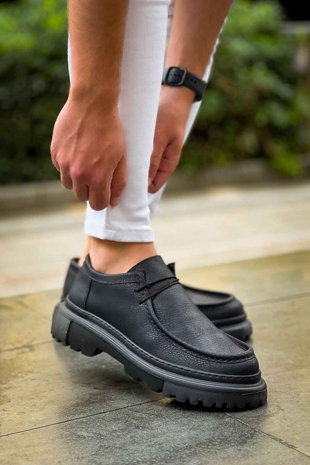 Men's black lace-up shoes with thick tread sole, front 3/4 view
