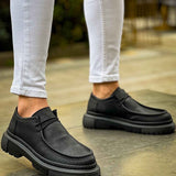 Men's black lace-up shoes with thick tread sole, pair shown on feet