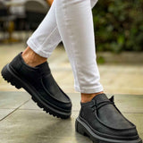 Men's black lace-up shoes with chunky rubber sole, stepping view