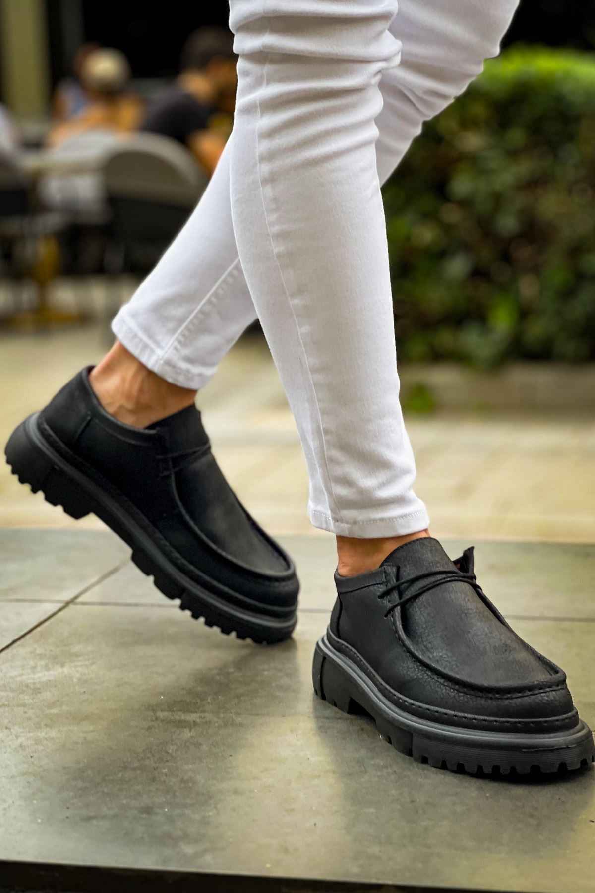 Men's black lace-up shoes with chunky rubber sole, stepping view