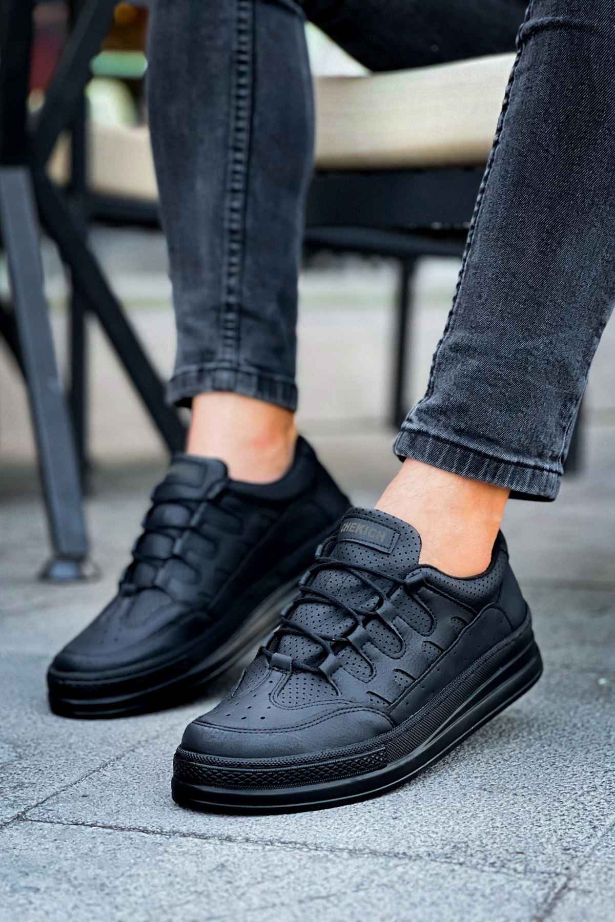 Men's black sneakers with lace-up front and chunky sole, angled view with jeans