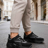 Men's black lace-up sneakers with dark gray panels and thick rubber sole