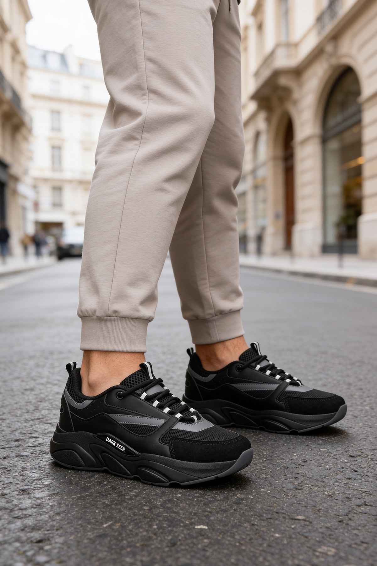 Men's black lace-up sneakers with dark gray panels and thick rubber sole
