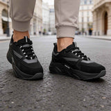 Men's black lace-up sneakers, two-quarter view, dark gray accents and tread sole