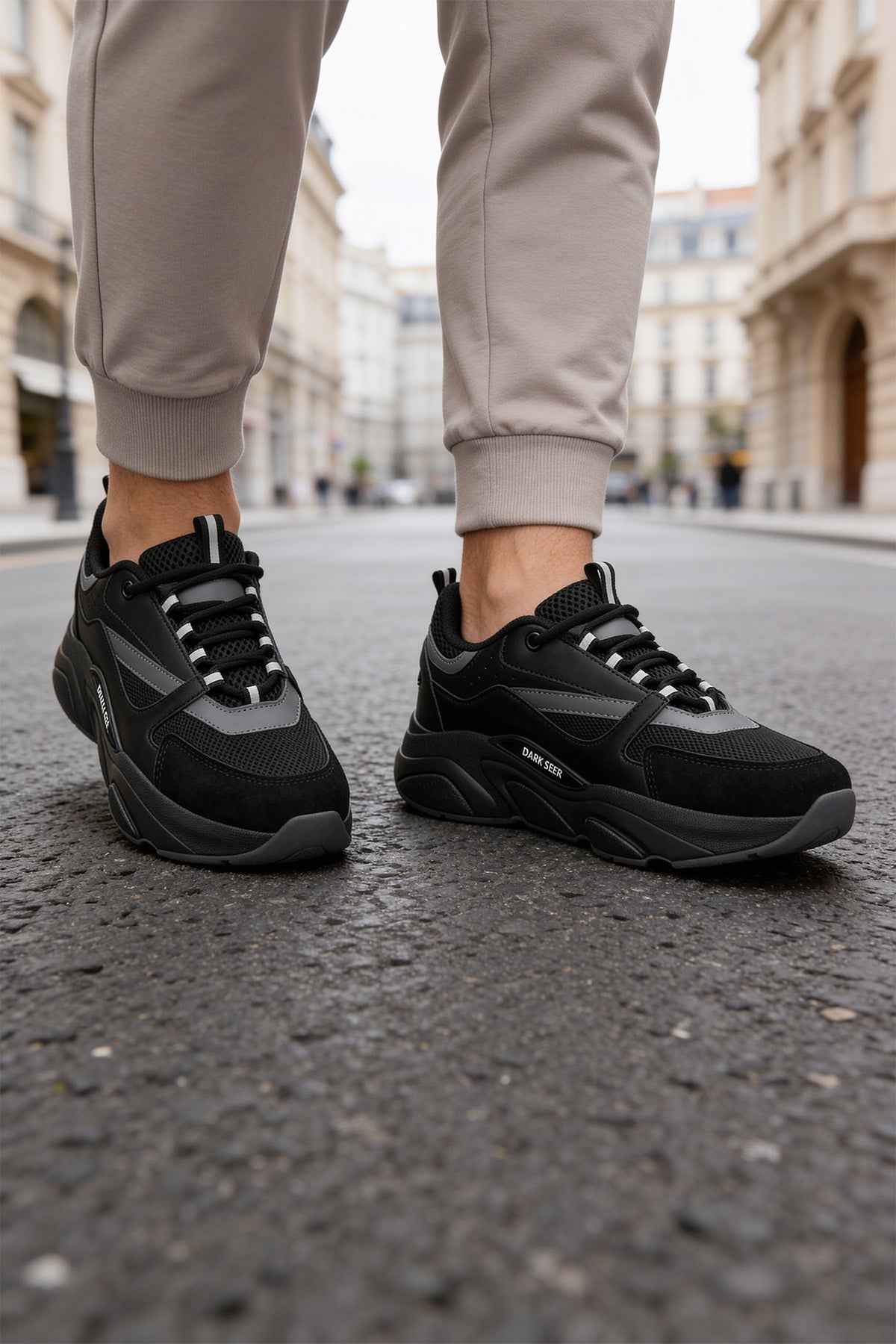 Men's black lace-up sneakers, two-quarter view, dark gray accents and tread sole