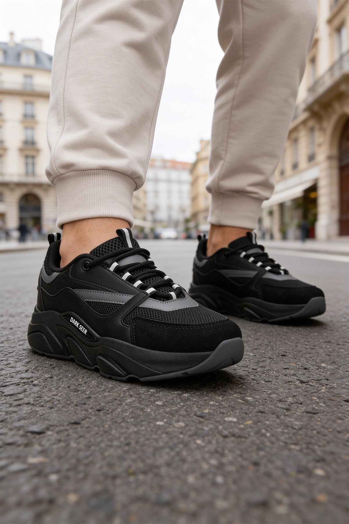 Men's black lace-up sneakers, close side view with textured outsole and gray accents