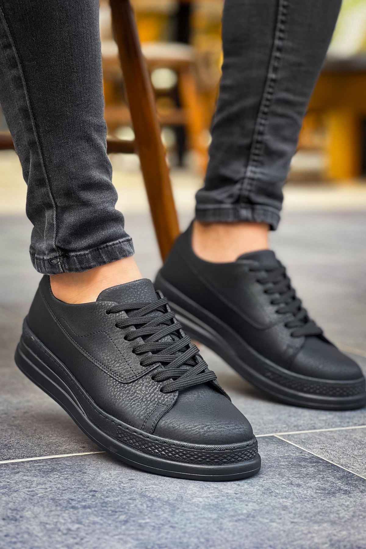 Men's black low-top sneakers with lace-up closure and dark rubber midsole