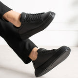 Men's black sneakers with lace-up closure and cushioned tongue, side angle