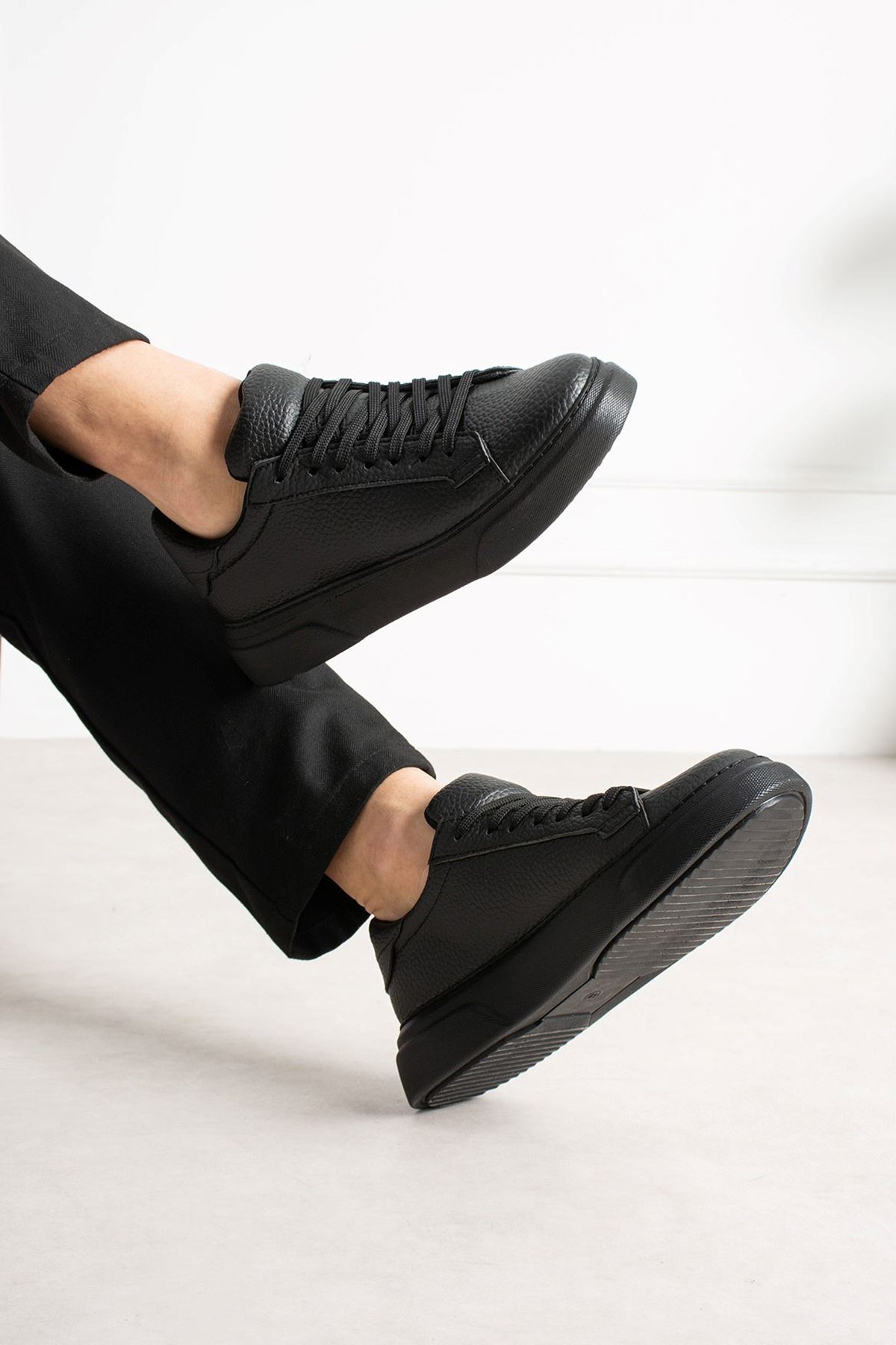 Men's black sneakers with lace-up closure and cushioned tongue, side angle