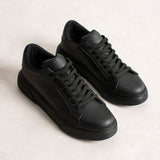Men's black sneakers pair, front/side view with lace-up design and rubber sole