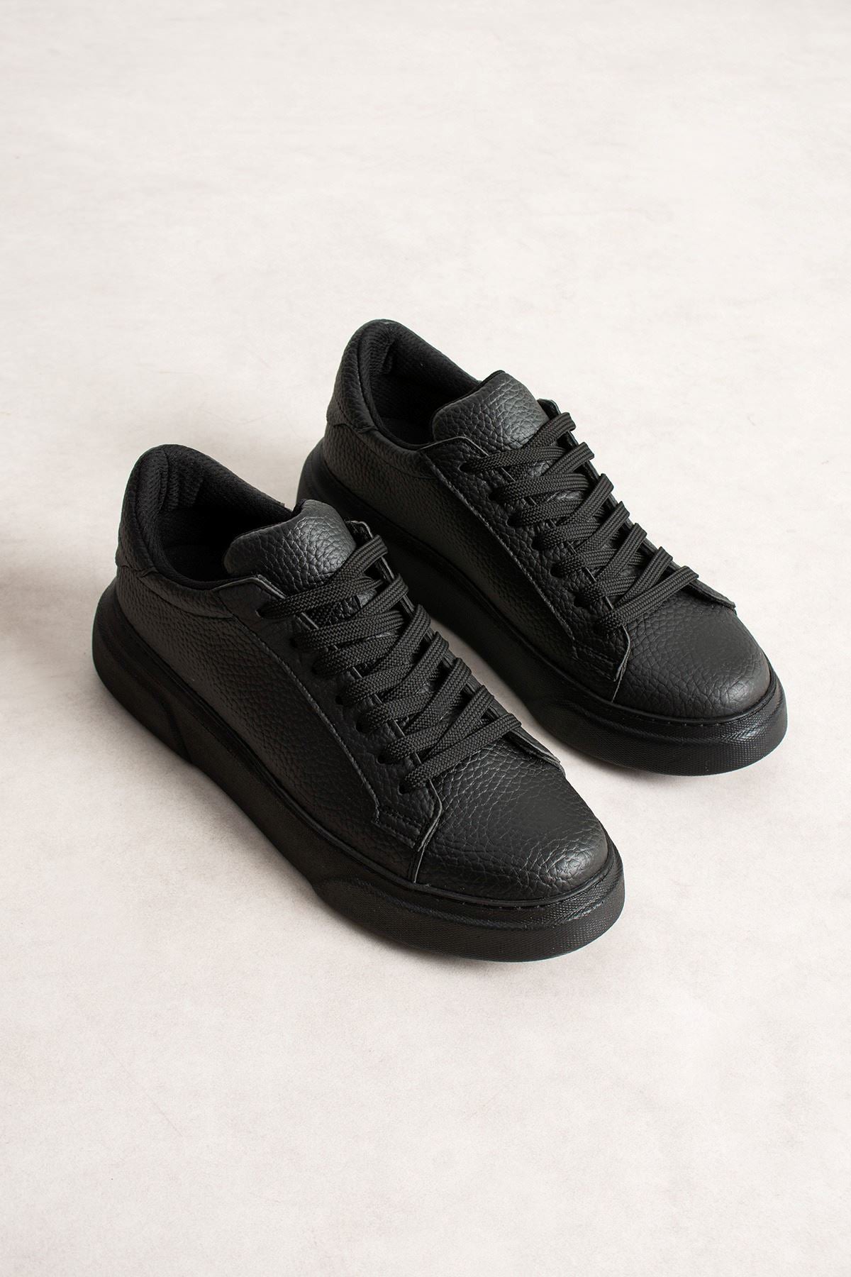 Men's black sneakers pair, front/side view with lace-up design and rubber sole