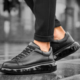 Black low-top sneakers, lace-up front and glossy toe panel