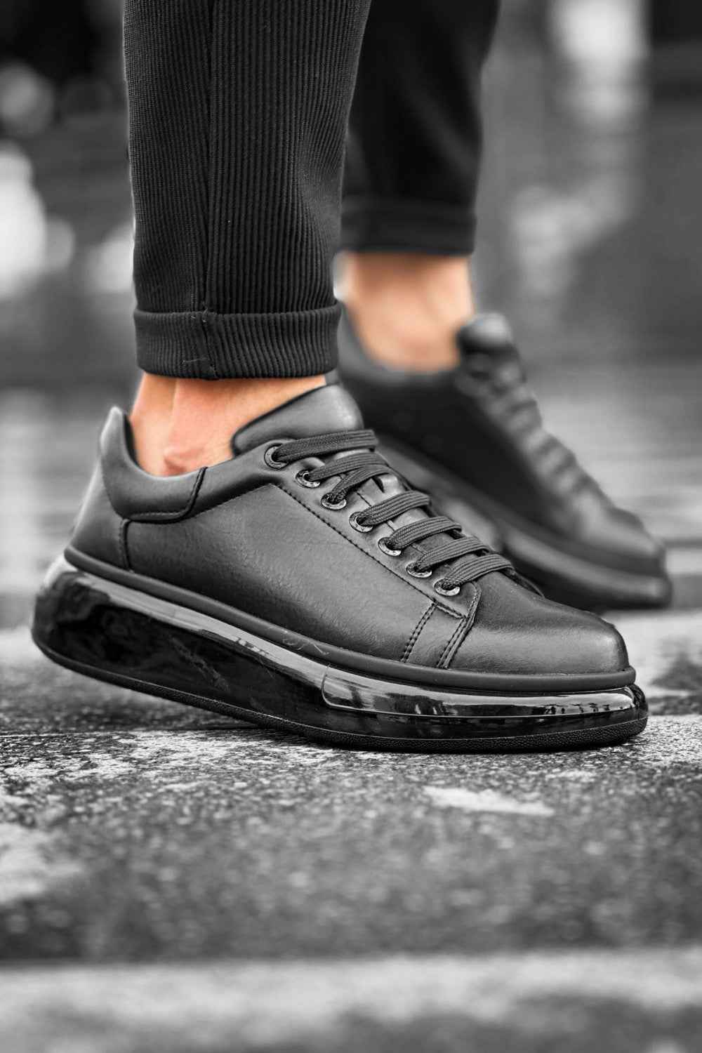 Black lace-up sneakers with textured rubber sole, side logo detail