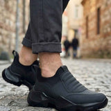 Men's black lace-up sneakers with angular side panels and cushioned rubber sole
