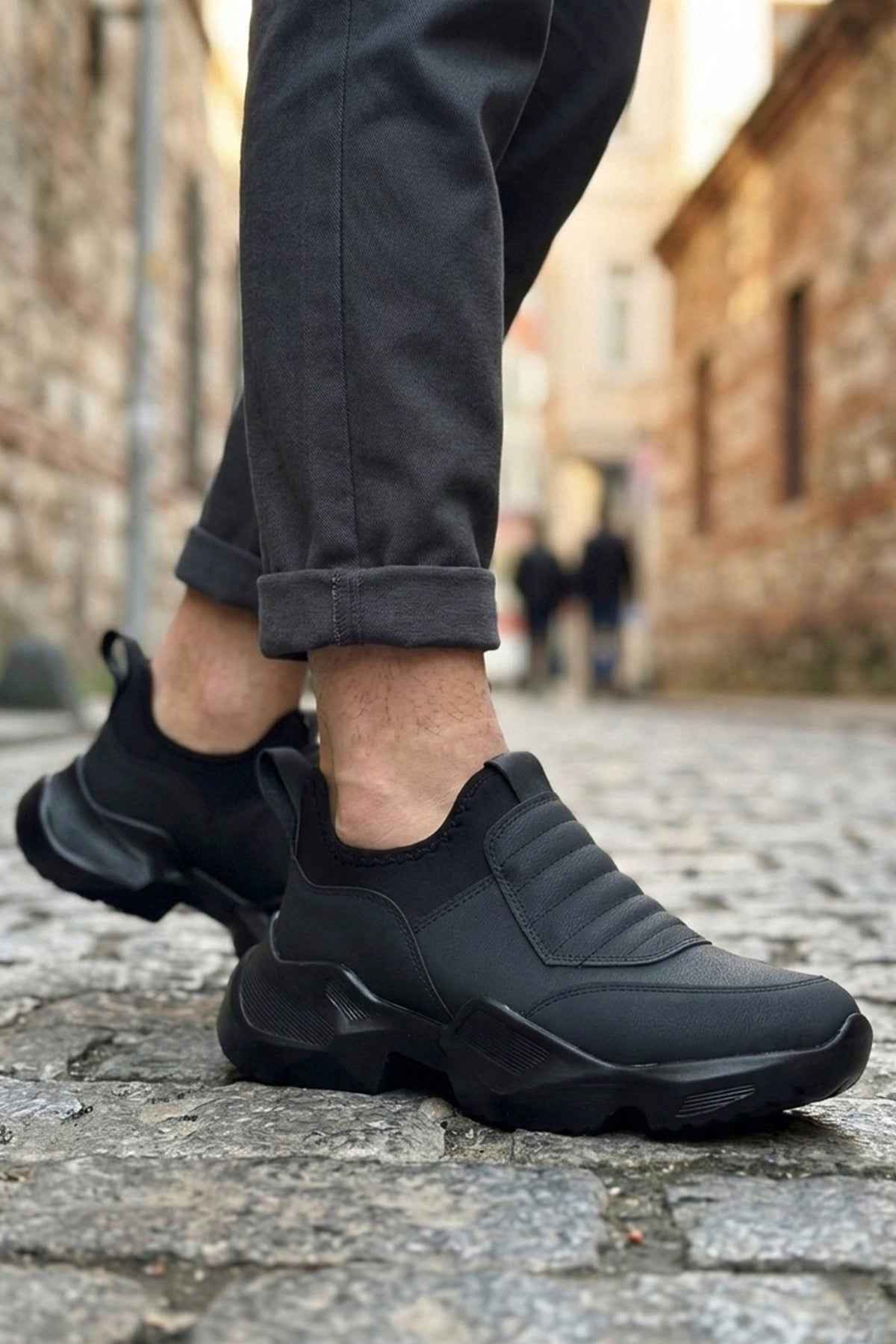 Men's black lace-up sneakers with angular side panels and cushioned rubber sole